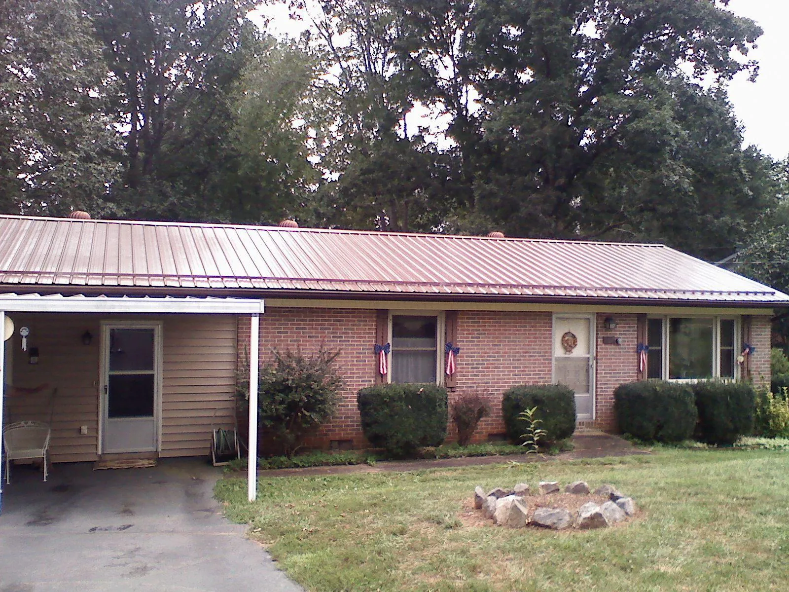 Bronze metal roof and carport on a brick ranch home — Roof Repair work by our crew in Oak Harbor